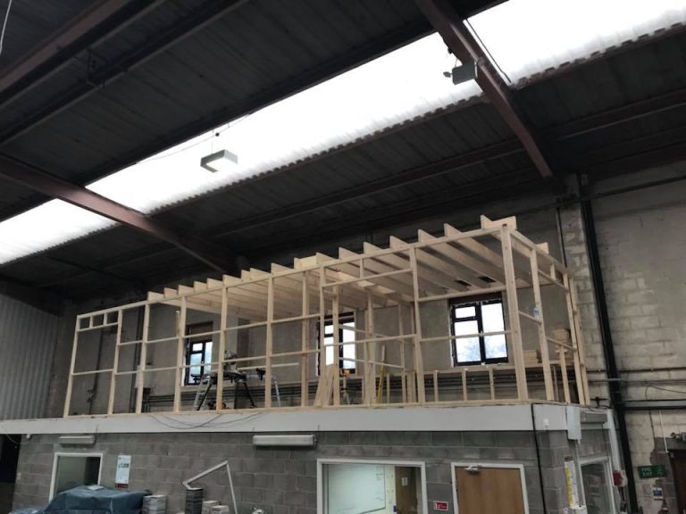 Wooden framework being constructed on the mezzanine level of the new Marble & Granite Designs office.