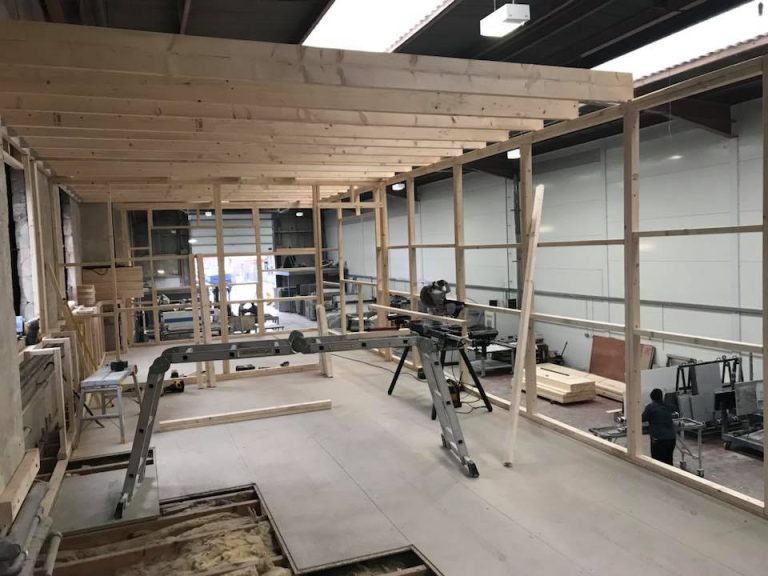 Wide view of the early framing phase for the new office space, showing beams and supports.