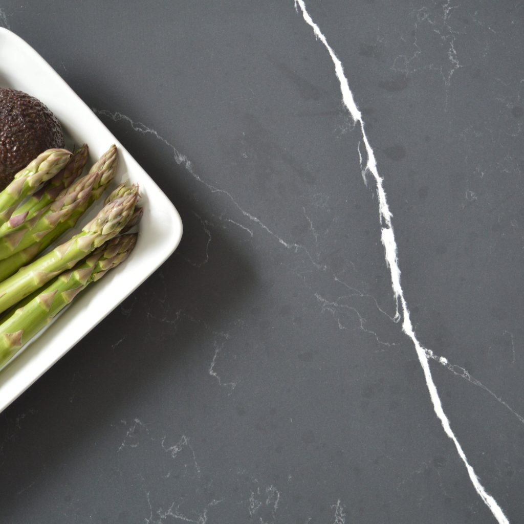 Poetic Black Technistone at MGD. A marble-effect quartz worktop weith a dark grey background and white veined pattern across the surface.