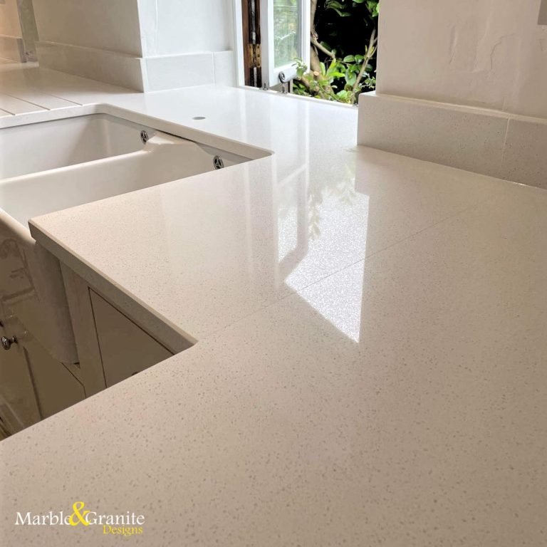 white worktops made of quartz by MGD, with upstands and Belfast sink cutout.
