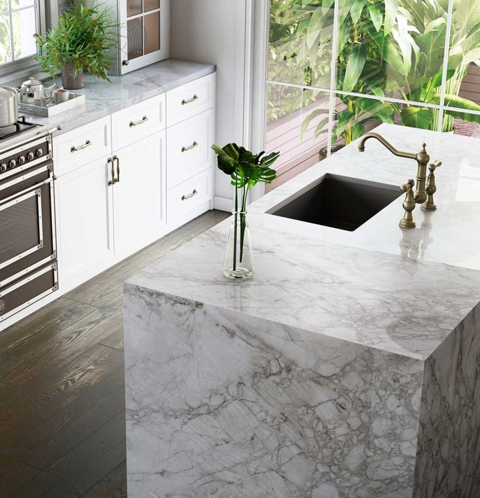 A white marble-effect dekton kitchen island in a modern setting with light decor.