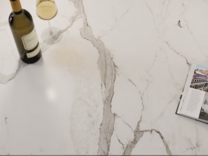 Dekton Daze marble-effect table-top with white wine glass and bottle, and a magazine laid out on top, open to a page about travel.