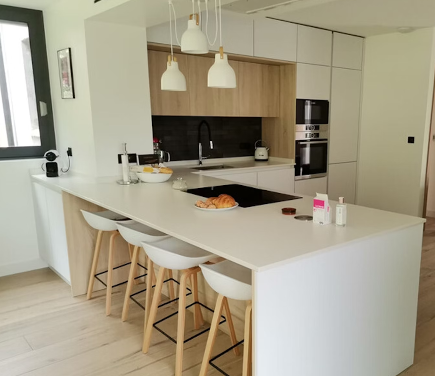 Dekton Uyuni roomshot featuring a solid colour breakfast-bar kitchen island with white stools in the foreground