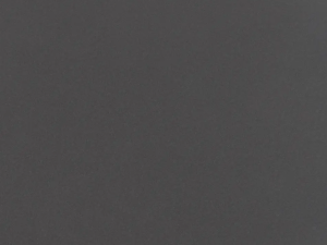 Fine-grained dark grey quartz compound stone with rounded paler fragments spread over the surface - Cemento Unistone swatch