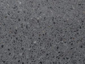 grey quartz surface with dark and light terrazzo fragments across the surface - Taurus Terazzo Technistone swatch