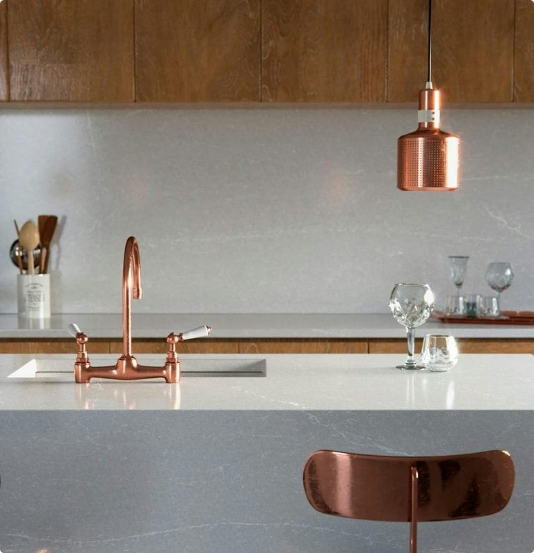 Silestone Wall Cladding and countertop surface with waterfall edge in a modern white and rose-gold decor kitchen.