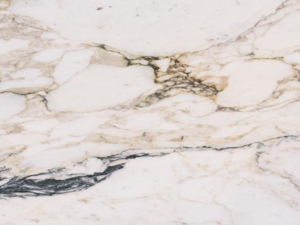 Product photo: Calacatta Monet Marble is a premium natural stone prized for its luxurious appearance and exquisite veining. This marble features a stunning white background, accented by striking gold and grey veins that flow gracefully across the surface. The combination of pure white with bold veining patterns gives it a distinctive and sophisticated look, making it a preferred choice for high-end interior design projects.