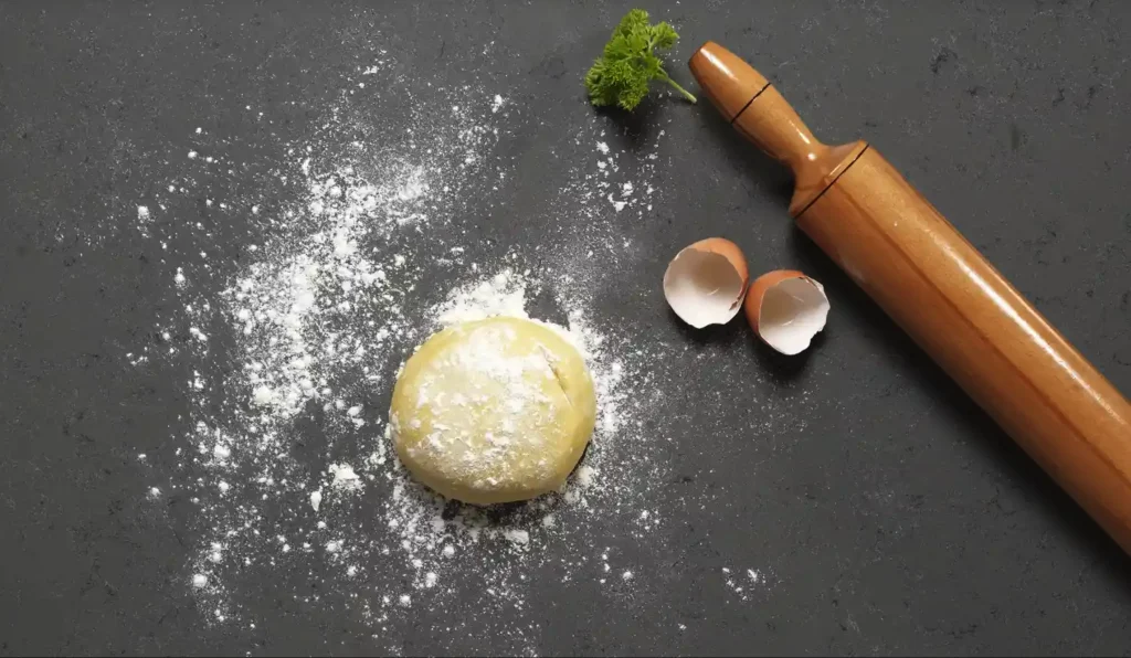 Cimstone Features | Rolling pin on dark grey quartz worktop with flour and pastry.